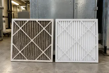 A clogged air filter next to a clean one